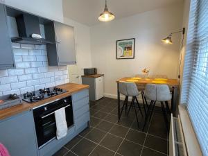 a kitchen with a counter and a table with stools at Beautiful Georgian Duplex in Gloucester