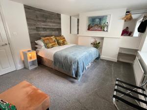 a bedroom with a bed with a wooden wall at Beautiful Georgian Duplex in Gloucester