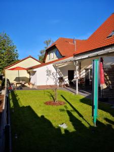 una casa con un patio con banderas en el césped en Pension und Ferienwohnung Walther, en Storkow
