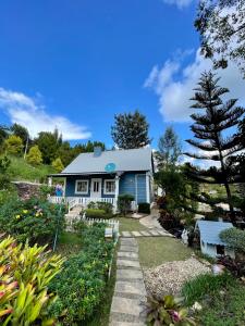 a blue house with a garden at Tip House in Khao Kho