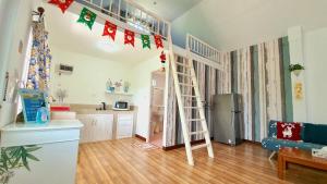 a living room with a loft bed and a kitchen at Tip House in Khao Kho