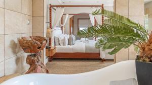 a bathroom with a tub and a bedroom with a bed at The Glen Boutique Hotel & Spa in Cape Town