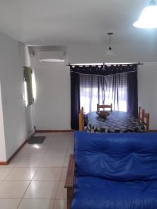 sala de estar con cama azul y ventana en Ayres Pampeanos en Santa Rosa