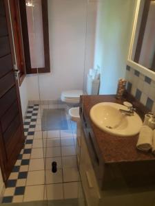 a bathroom with a sink and a toilet at Ouro Sobre Azul Apart Hotel in Arraial d'Ajuda