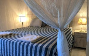 a bedroom with a blue and white bed with a canopy at Ouro Sobre Azul Apart Hotel in Arraial d'Ajuda