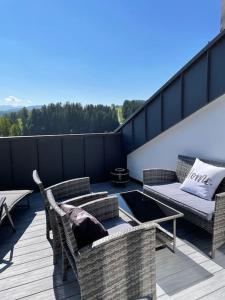 a patio with chairs and a couch and a table at Traumhafter Bergblick im Allgäuer Luftkurort in Buchenberg