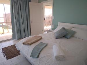 1 dormitorio con 1 cama con 2 toallas en CoCo de Mer Self Catering Log 1, en Lambertʼs Bay