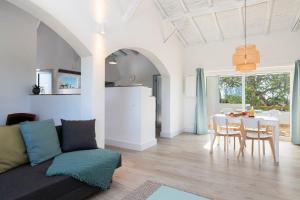 a living room with a couch and a table at Palmeiras Cottages in Mexilhoeira Grande