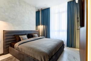 una camera da letto con un grande letto con tende blu di KADOR HOME HOTEL downtown a Kiev