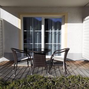 un tavolo e sedie su una veranda con porta in vetro di Apartment Kampenwand a Aschau im Chiemgau