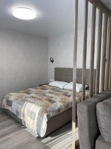 a bedroom with a bed and a couch at Prestige Apartments Berezinka in Dnipro