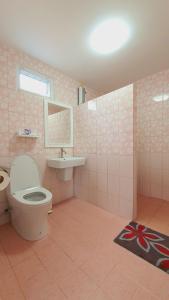 a pink bathroom with a toilet and a sink at Tip House in Khao Kho