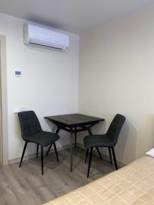 a table and two chairs in a room at Prestige Apartments Berezinka in Dnipro
