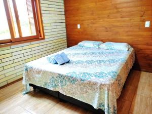 ein Schlafzimmer mit einem Bett mit blauen Kissen darauf in der Unterkunft Sítio da Figueira in Praia Grande