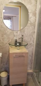 W łazience znajduje się umywalka i lustro. w obiekcie Gîte Des Quinconces w mieście Richelieu