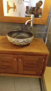 a bathroom sink with a bowl on a wooden counter at Villa Teranga in Saly Portudal