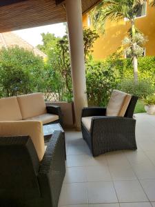 um pátio com 2 cadeiras, uma mesa e um sofá em Villa Teranga em Saly Portudal