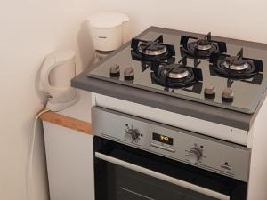 a stove top oven in a small kitchen at Gîte Des Quinconces in Richelieu