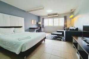 een hotelkamer met een bed en een bank bij The Studio at Sathorn Terrace in Bangkok