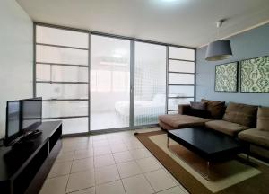 ein Wohnzimmer mit Sofa und Tisch in der Unterkunft The Studio at Sathorn Terrace in Bangkok