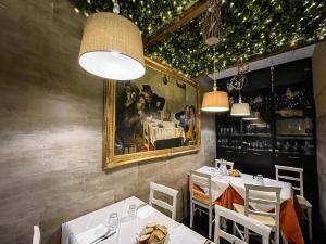 a restaurant with two tables and a picture on the wall at Locanda il Deserto in Livorno