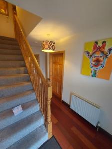 a stairway with a painting of a cow on the wall at Village Lodge - Carlingford in Carlingford