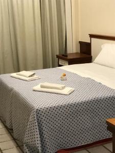 a bedroom with a bed with two towels on it at Flat Pasárgada Encantador 616 in Vila Velha
