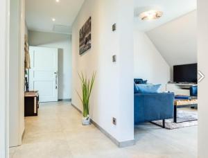 ein Wohnzimmer mit einem blauen Sofa und einem TV in der Unterkunft Haus MEERLE in Zingst