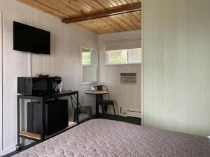 1 dormitorio con 1 cama, TV y mesa en The River Hills Motel - Algoma, WI - Near Door County, en Algoma