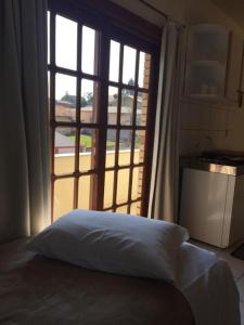 a bed in a room with a large window at Villa Apart Hotel in Lages