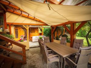 einen Holztisch und Stühle in einem Zimmer mit Zelt in der Unterkunft Hunting Lodge Lipót in Lipót