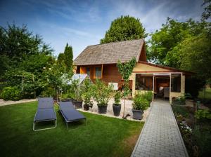 einen Hof mit zwei Stühlen und einem Haus in der Unterkunft Hunting Lodge Lipót in Lipót