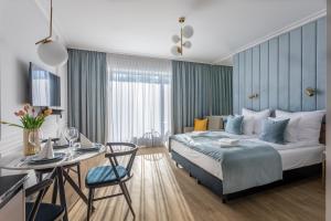 une chambre d'hôtel avec un lit et une table dans l'établissement Apartpark - Ambria Apartments, à Świnoujście