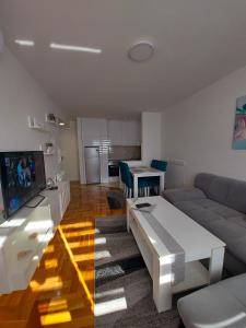 ein Wohnzimmer mit einem Sofa und einem Tisch in der Unterkunft Apartman Victoria in Lukavica