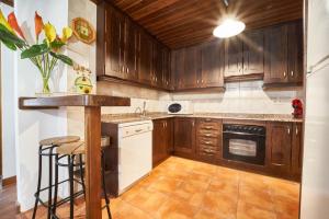 a kitchen with wooden cabinets and a counter top at Mountain Chalet Baqueira Beret in Unha +12 photos