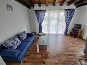 a living room with a blue couch and a table at Apartman Niki in Lič