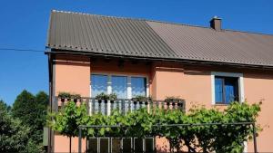 una casa con techo negro y valla en Apartman Niki en Lič