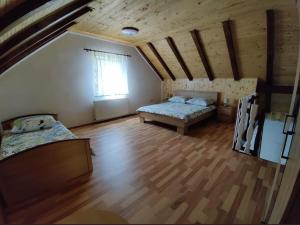 a attic room with two beds and a window at Apartman Niki in Lič