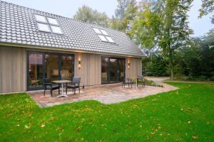 een patio met een tafel en stoelen voor een huis bij Bed & Wijn - Suite 1 in Staphorst