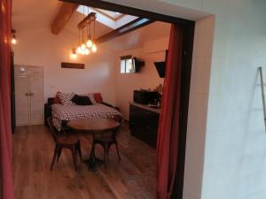 a room with a table and chairs and a kitchen at L'atelier de Guytou et Spa in Cheval-Blanc