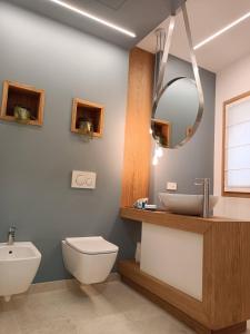 bagno con lavandino, servizi igienici e specchio di Vecchia Bastia Lodge a Castelfranco Veneto