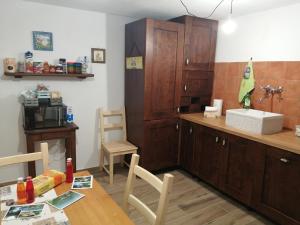 a kitchen with wooden cabinets and a table and a sink at Borgo Don Camillo in Cutigliano +16 photos
