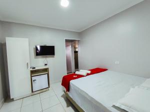 Saloá的住宿－Barra Nova Hotel，卧室配有一张床,墙上配有电视。