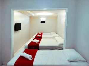 Un grupo de 4 camas en una habitación en Barra Nova Hotel, en Saloá