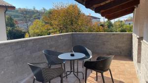 un patio con mesa, sillas y pared en MADONCA ROOMS & RESTAURANT en Nova Gorica