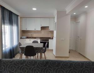 una cucina e una sala da pranzo con tavolo e sedie di Apartamento Estels a L'Ampolla Altre 2 foto