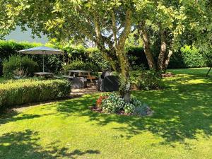 - un parc avec une table de pique-nique et un parasol dans l'établissement Chambre d'Hôtes L'Airial, à Liposthey