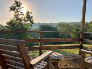 eine Holzbank auf einer Veranda mit Aussicht in der Unterkunft Gumbo Limbo Jungle Resort in Cool Shade
