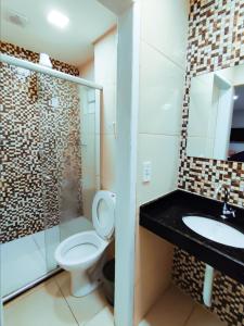 a bathroom with a toilet and a sink at Barra Nova Hotel in Saloá