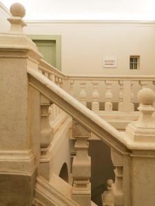 uma escada num edifício com um sinal na parede em Palazzo Cortesi em Macerata